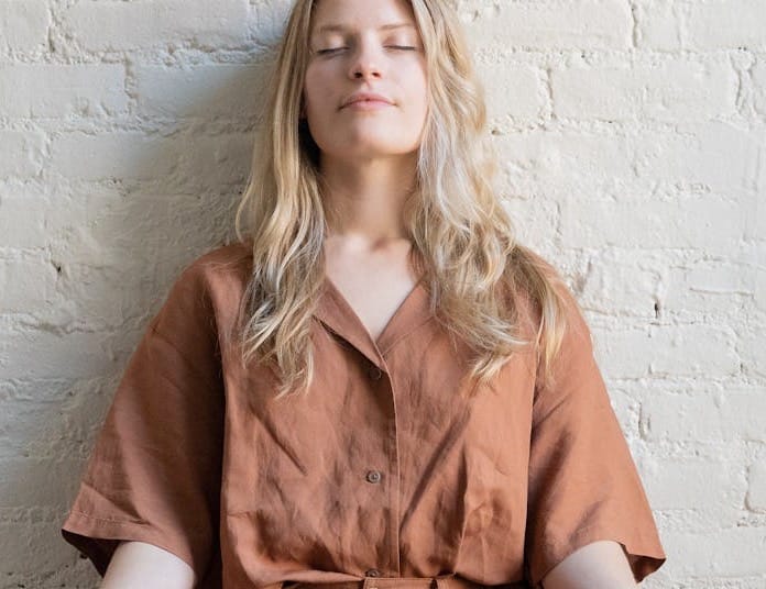 Free Woman meditating indoors, practicing mindfulness and relaxation in a calm setting. Stock Photo